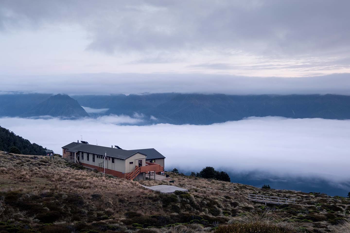Luxmore hut situated above the clouds in the early morning light. Luxmore is one of three huts found on the Kepler Track.